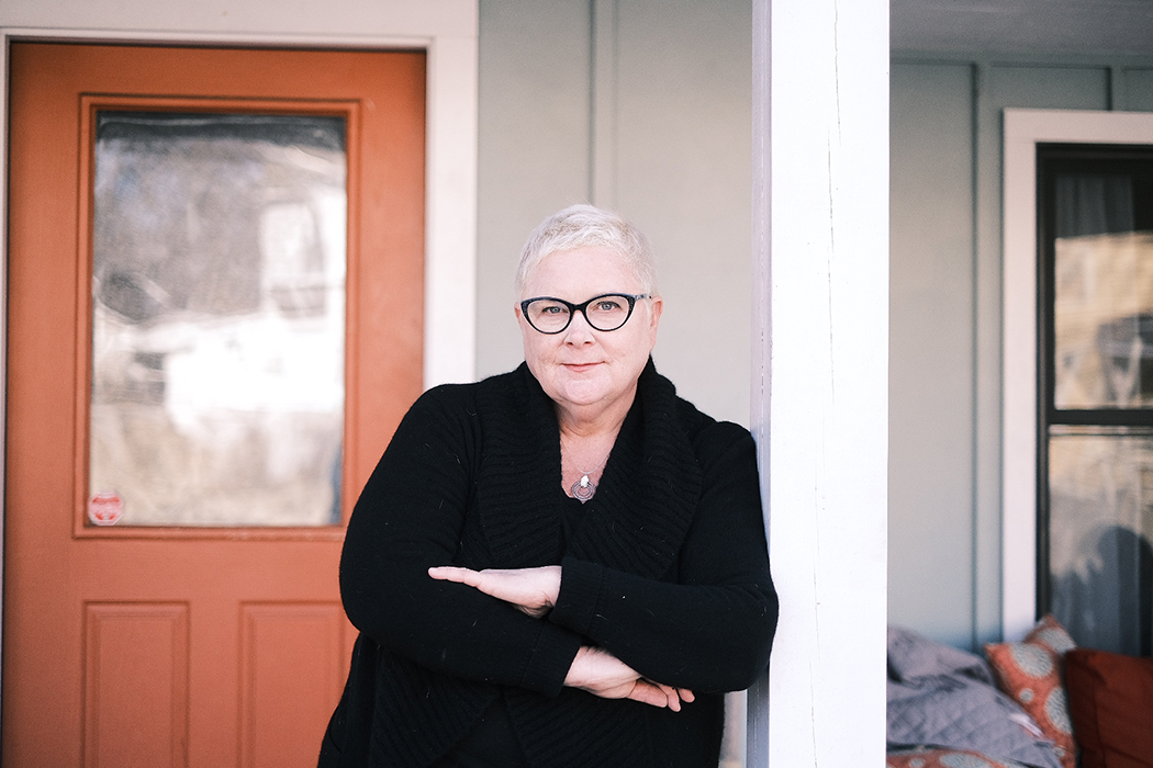 Human Rights Commission chair Mary Bauer stands in front of a door.