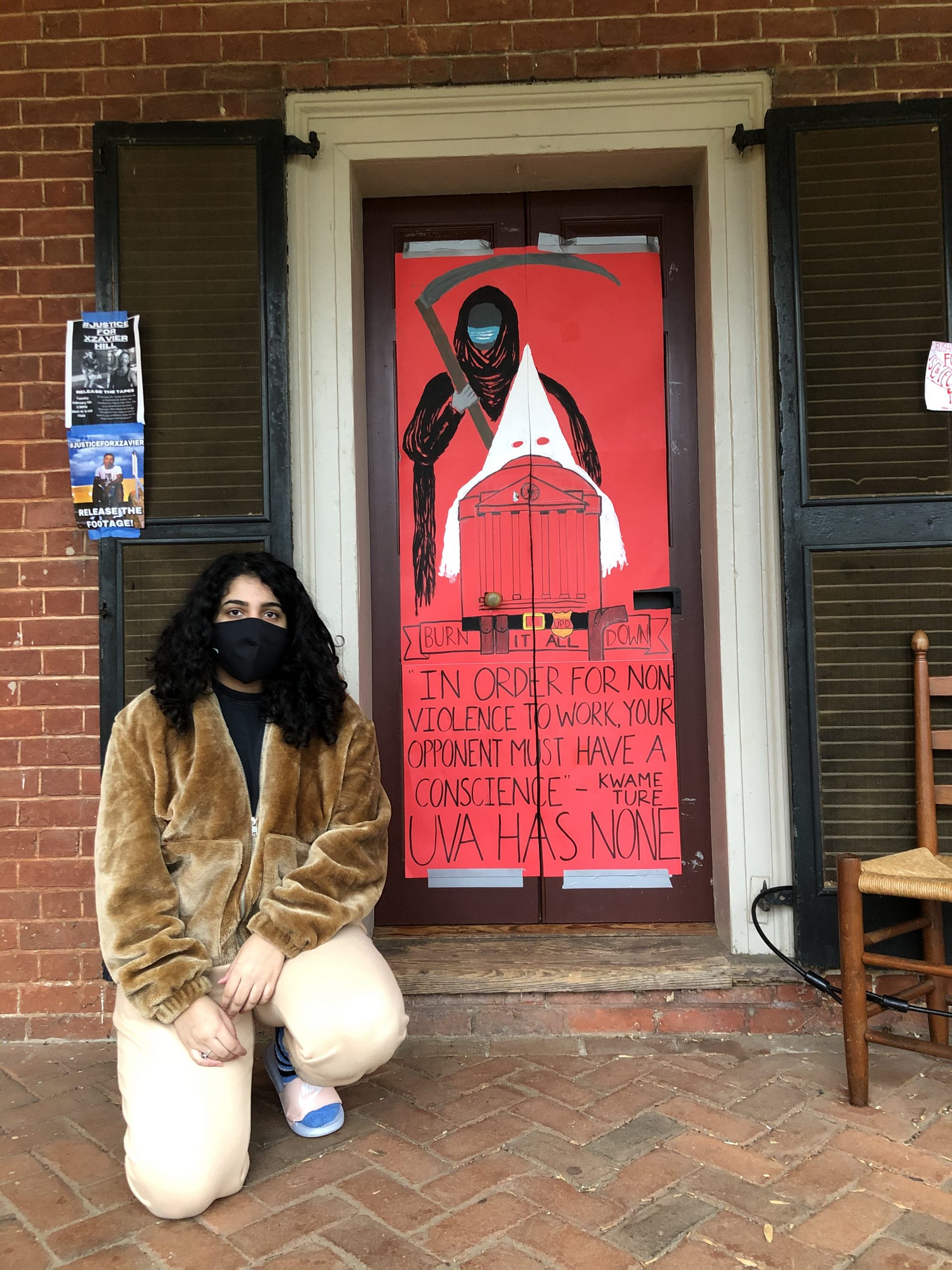 Hira Azher kneels on the ground in front of her Lawn room sign