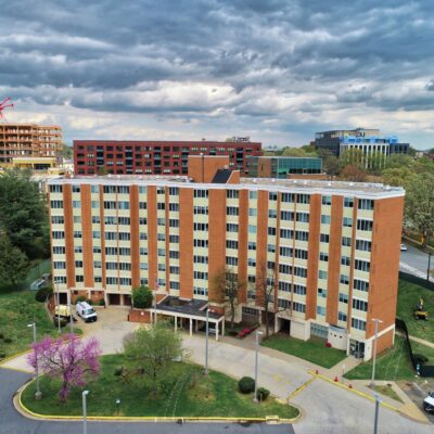 Exterior photo Crescent Halls, an eight-story tall tan apartment building with 105 units