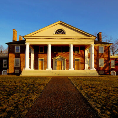 front view of Montpelier during sunset showing four white columns topped by triangle archway