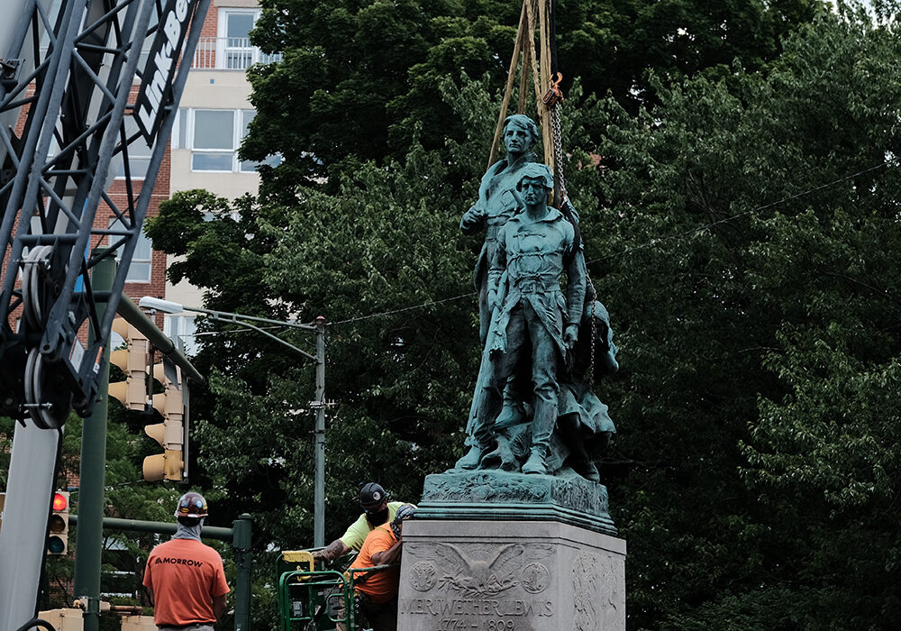 Lewis Clark and Sacajawea statue about to be lifted in the air by a crane