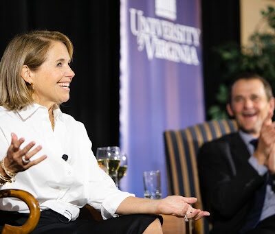 Journalist Katie Couric sitting in a chair next to UVA president Jim Ryan